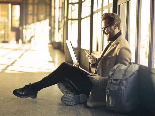 A businessman traveling, while checking his company's intranet to find a necessary contract for an upcoming meeting.