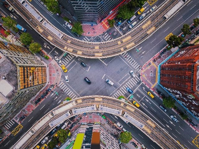 Aerial view of cars and trains in intersection in downtown Taipei, Taiwan.  