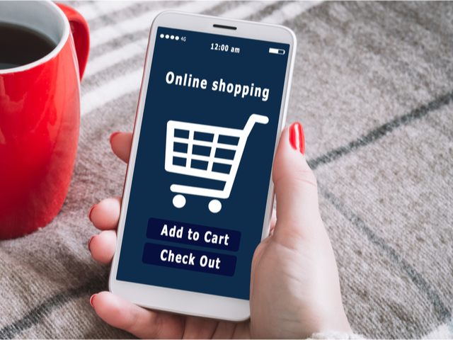 A woman using her mobile phone is shopping at an online store - ecommerce concept