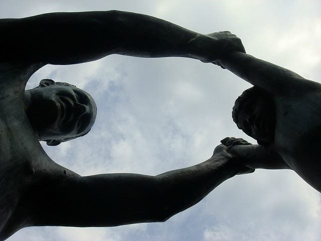 statue of man swinging young boy by the arms