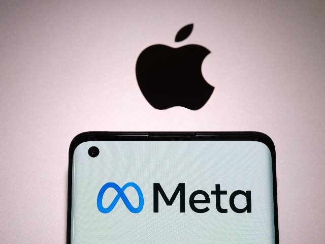 Meta company logo seen on smartphone, which is placed on top of macbook with apple logo visible in piece about Apple versus Meta in mixed reality. 