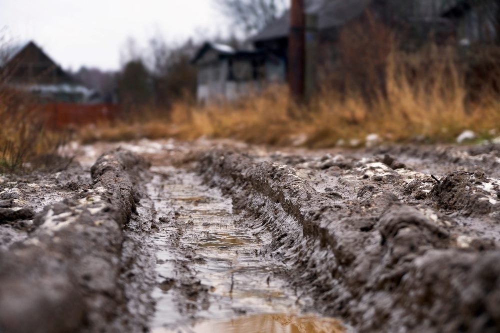 A deeply cut rut in a dirt road in a rural setting in piece about B2B strategies and avoiding automation ruts.