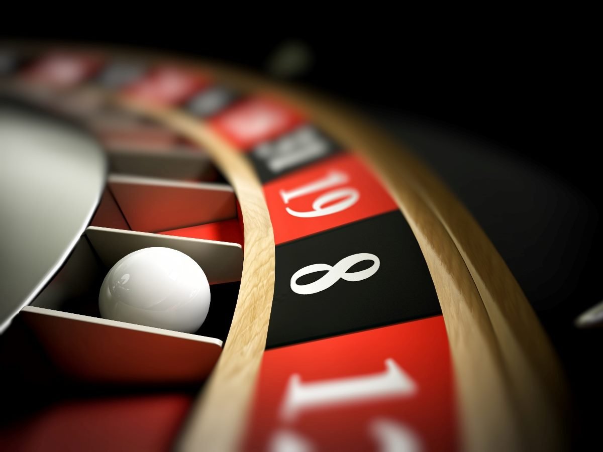 Close-up view of a roulette wheel with the ball resting on the black number 8 slot, surrounded by red and black numbered sections.