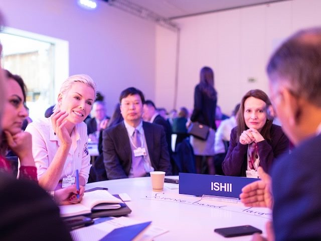group of people sitting around a table having a conversation