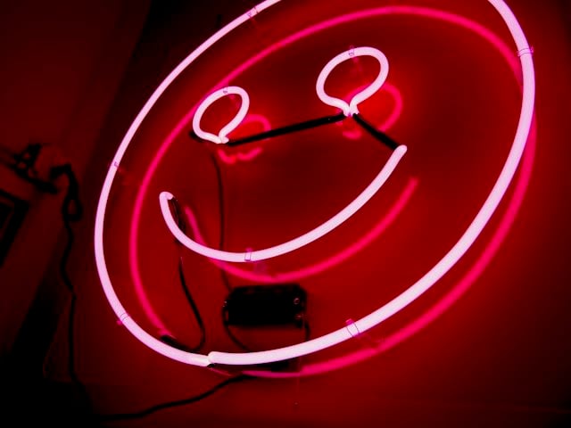 pink neon emoji smiley face sign