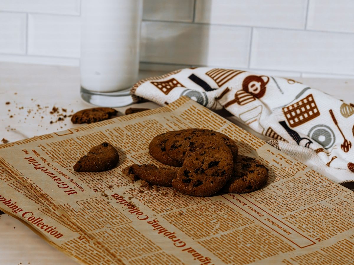 Cookies crumbled on a newspaper.