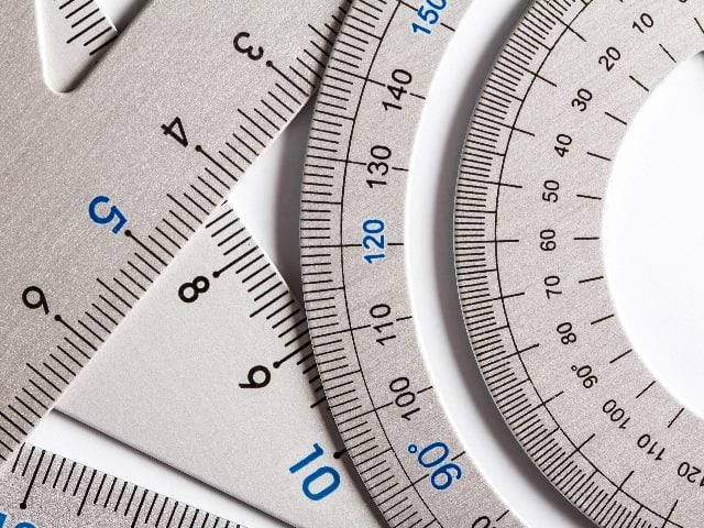 Close up of several silver precision measurement tools in the shapes of triangles, circles and sticks in piece about customer experience metrics. 