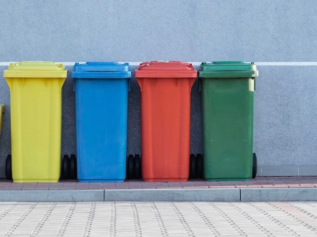 four trashcans in primary colors and green