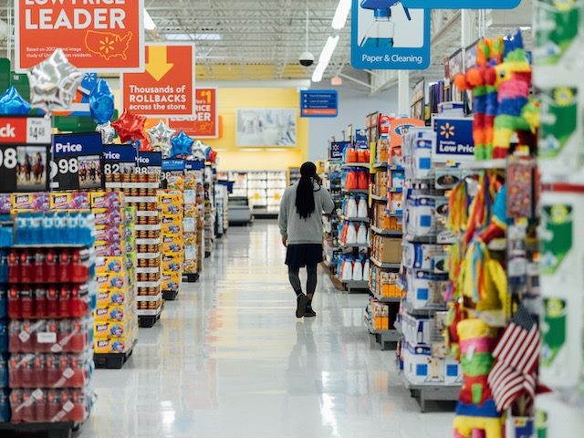 man walking through the aisles of an overcrowded big box store