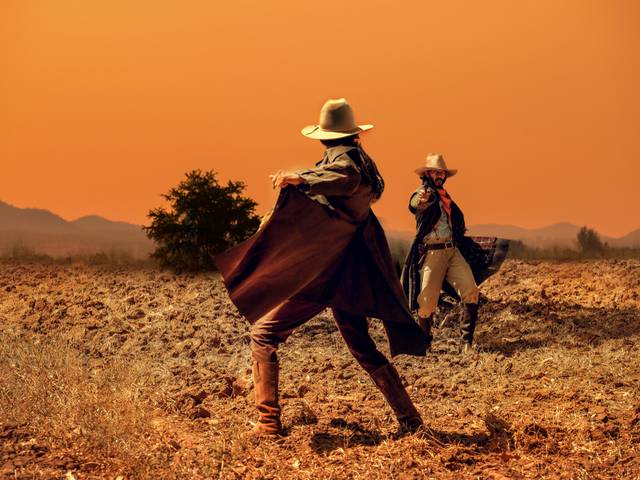Two cowboys in a gun pointing standoff - CMS Showdown Concept