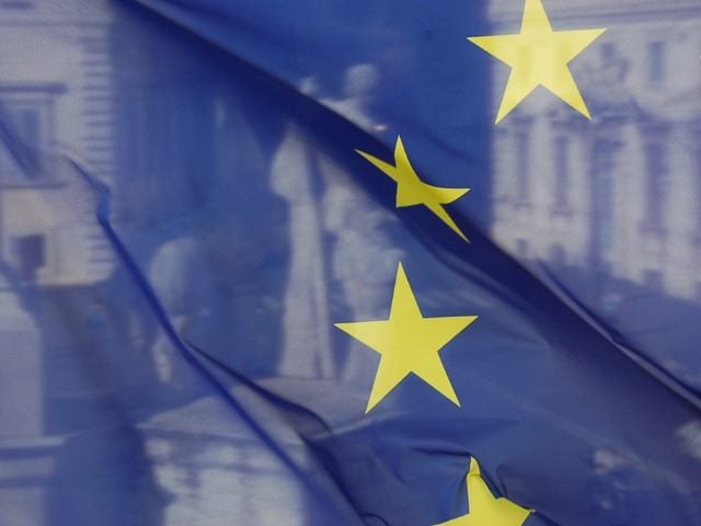 EU flag with a statue behind it