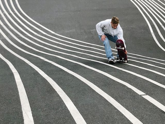 skateboarder in park with wavy lines forming tracks