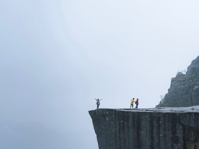 people standing at the edge of a cliff