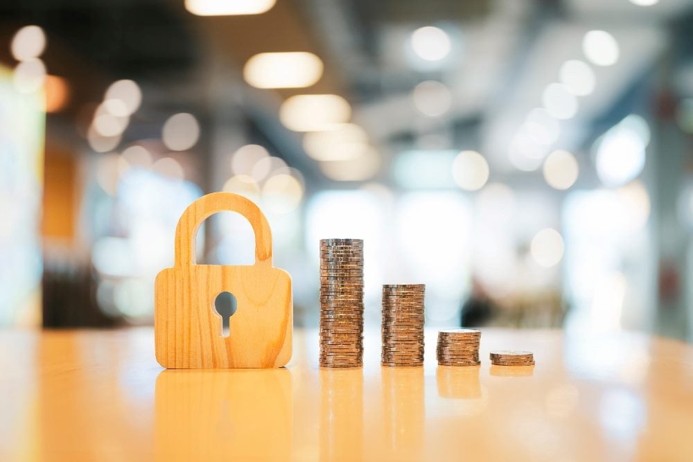 The symbol of the lock and four coins stacked up, with each pile of coins shrinking as it goes to the right.