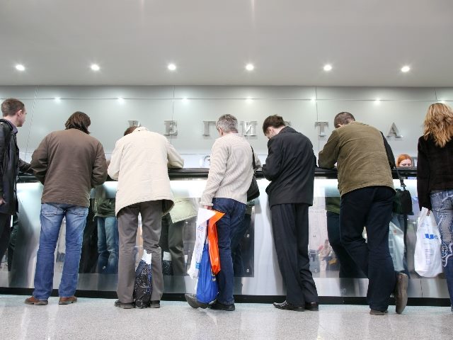 People waiting in line at a desk.