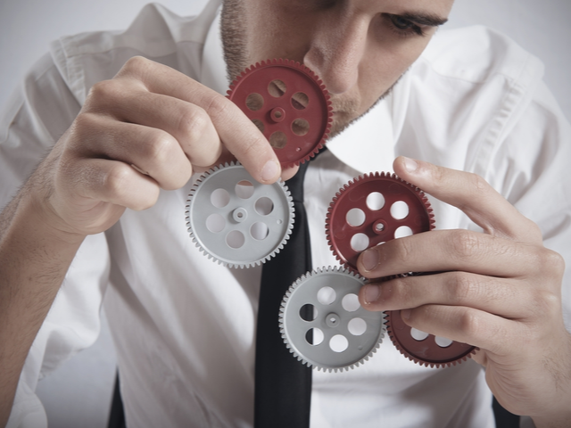 A businessman working with gears - building concept