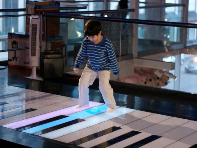 child playing with big piano