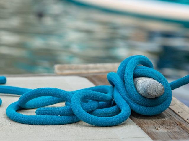 Blue boat rope tied to a dock.