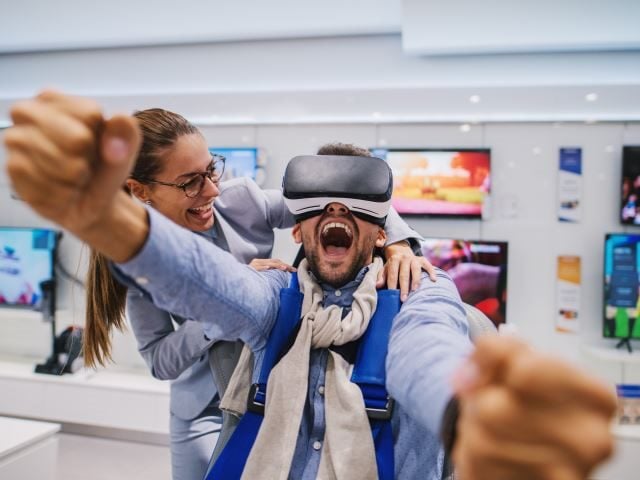 An excited man in a store experiencing virtual reality - future cx concept