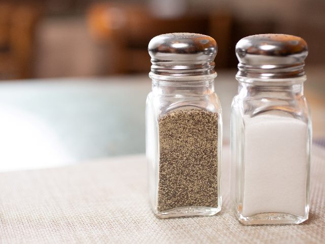 Clear salt and pepper shakers with silver metal tops and nearly to their tops sit on a table on a natural colored placemat, symbolizing the need for journey orchestration and experience management together. 