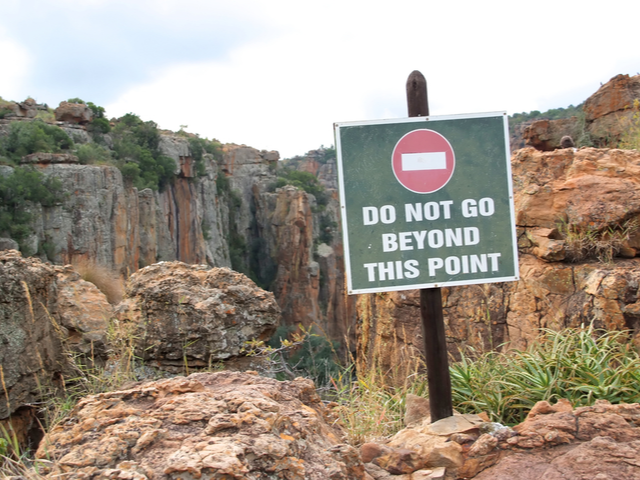 A sign post warning not to go beyond this point or fall over the cliff - beyond digital transformation concept