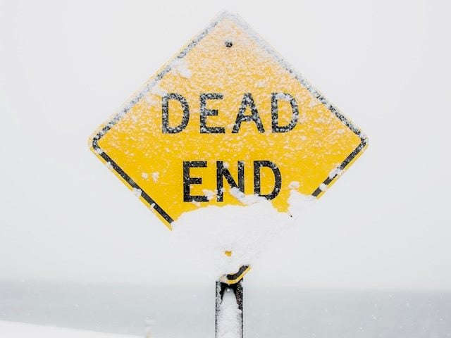 dead end sign covered in snow