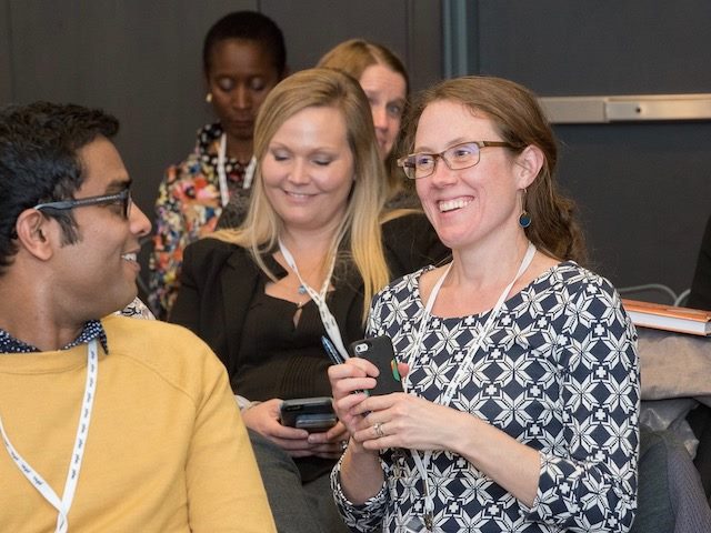 a group of conference attendees laughing