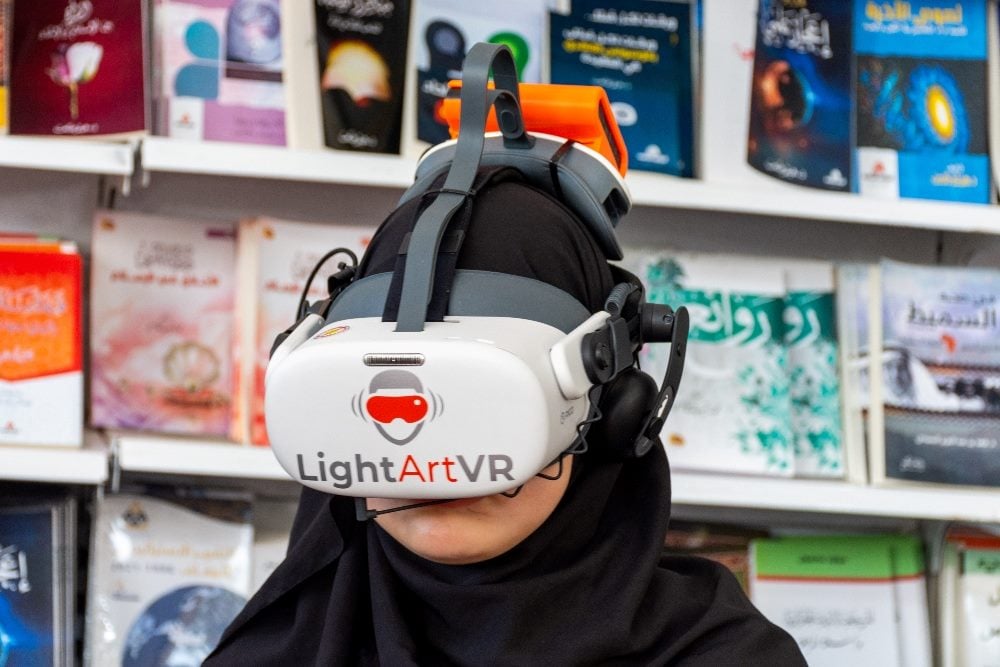 A girl explores a virtual reality world at the Algiers International Book Fair 2024, Algeria.