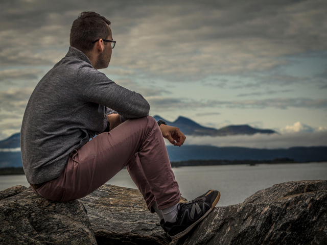 A young CMO sitting on a coastline in deep thought