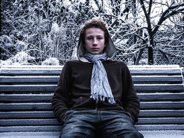 man sitting on a park bench in winter