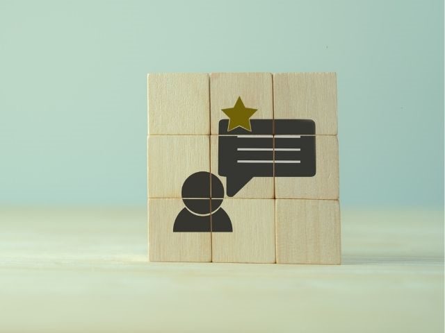 Wooden cubes with a customer and a speech bubble icons