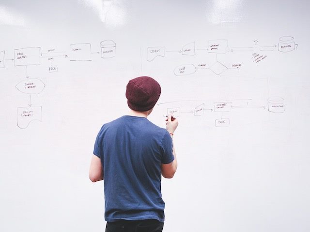 man writing on a whiteboard