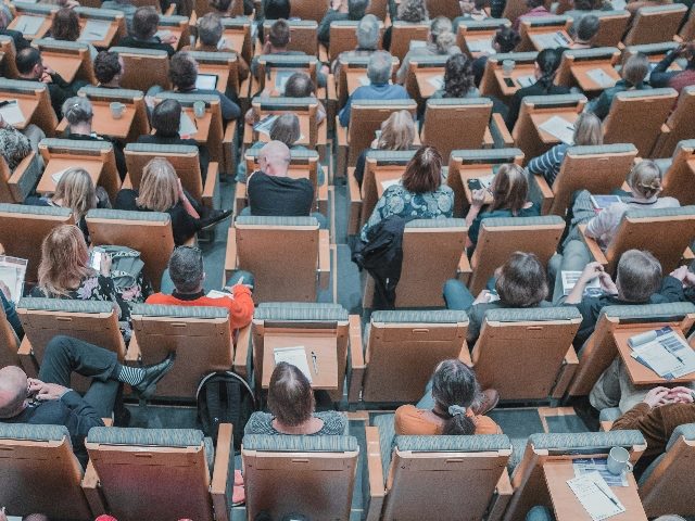 Overhead shot of people sitting down at a meeting or conference.