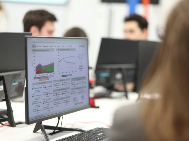 An employee reviews a data dashboard on a computer monitor.