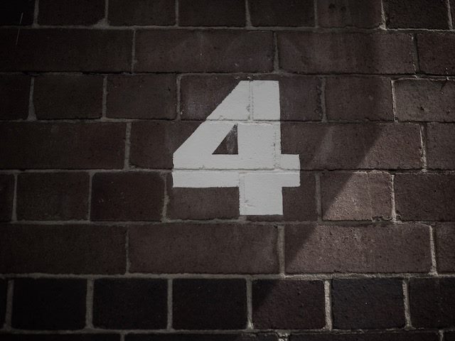 number four painted on a brick wall 