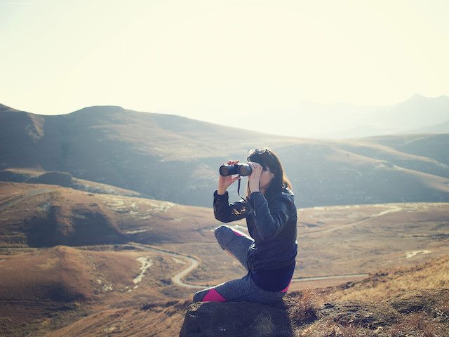 woman looking through binoculars