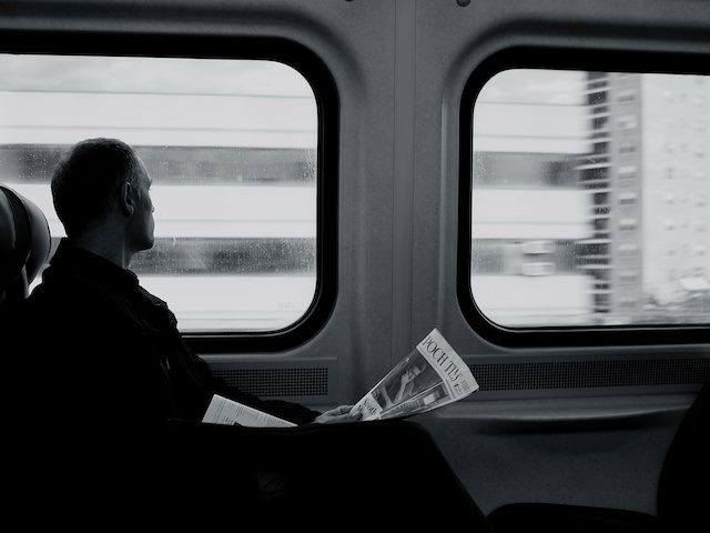 man on train with newspaper