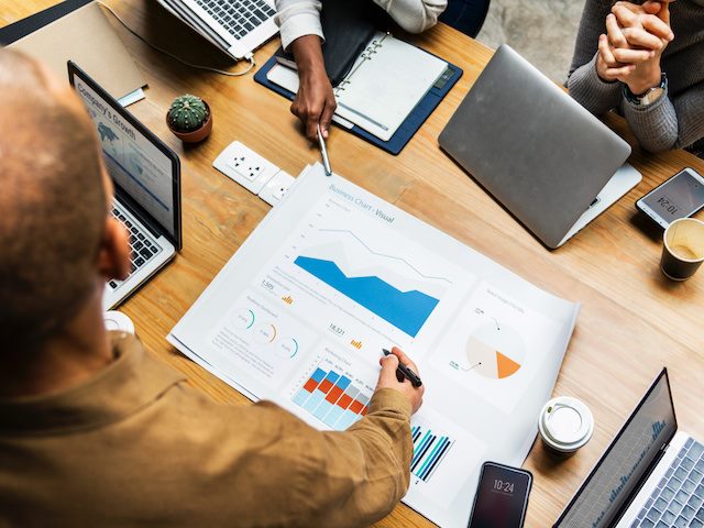 meeting at a table with a chart depicting growth