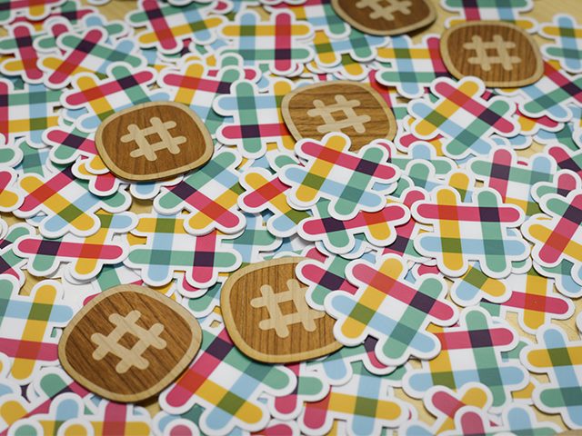 Image of stickers of the Slack logo sprawled out across a table. 