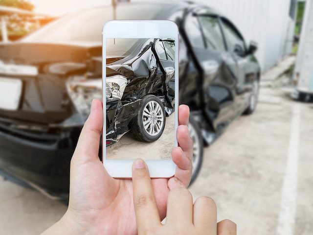 person taking photo of car after an accident