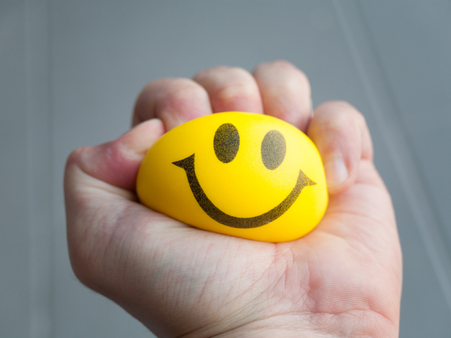 A man's hand squeezing a stress ball