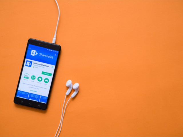 mobile phone with SharePoint on screen, sitting on an orange background