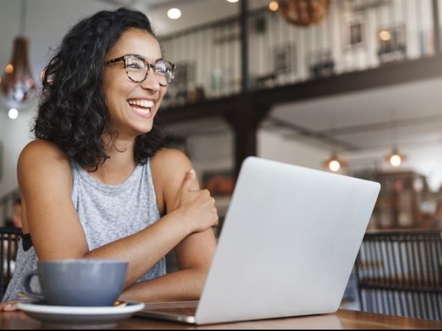 A carefree worker interacting with an internal chatbot on a laptop to schedule some vacation time