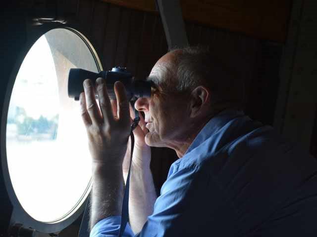 a man using binoculars to look through a window