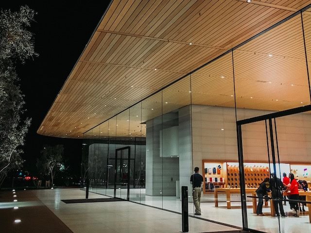 a lit up retail store at night, photographed from outside