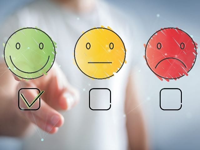 A smiley face, a neutral face, and a sad face in green, yellow and red respectively with boxes underneath with the smiley face box checked in piece about AI integration. 