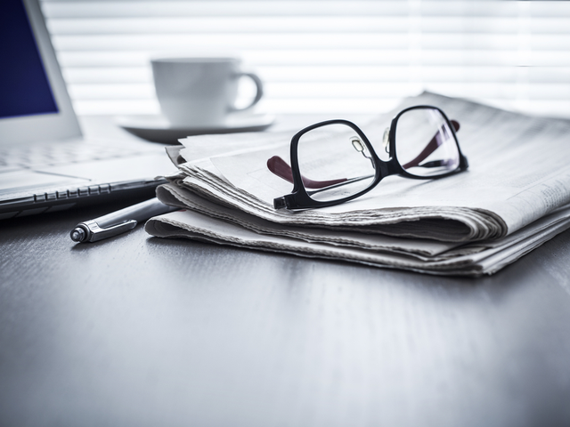 pair of glasses on top of newspapers