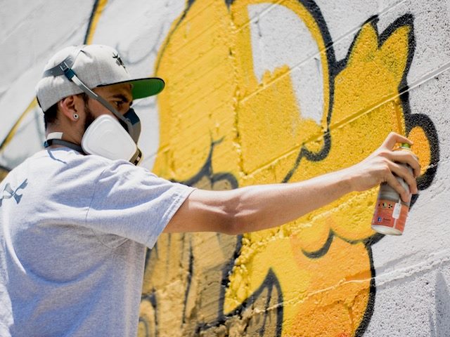 graffiti artist painting on a wall