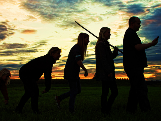 evolving businessmen standing in a line silhouetted on a sky with a setting sun
