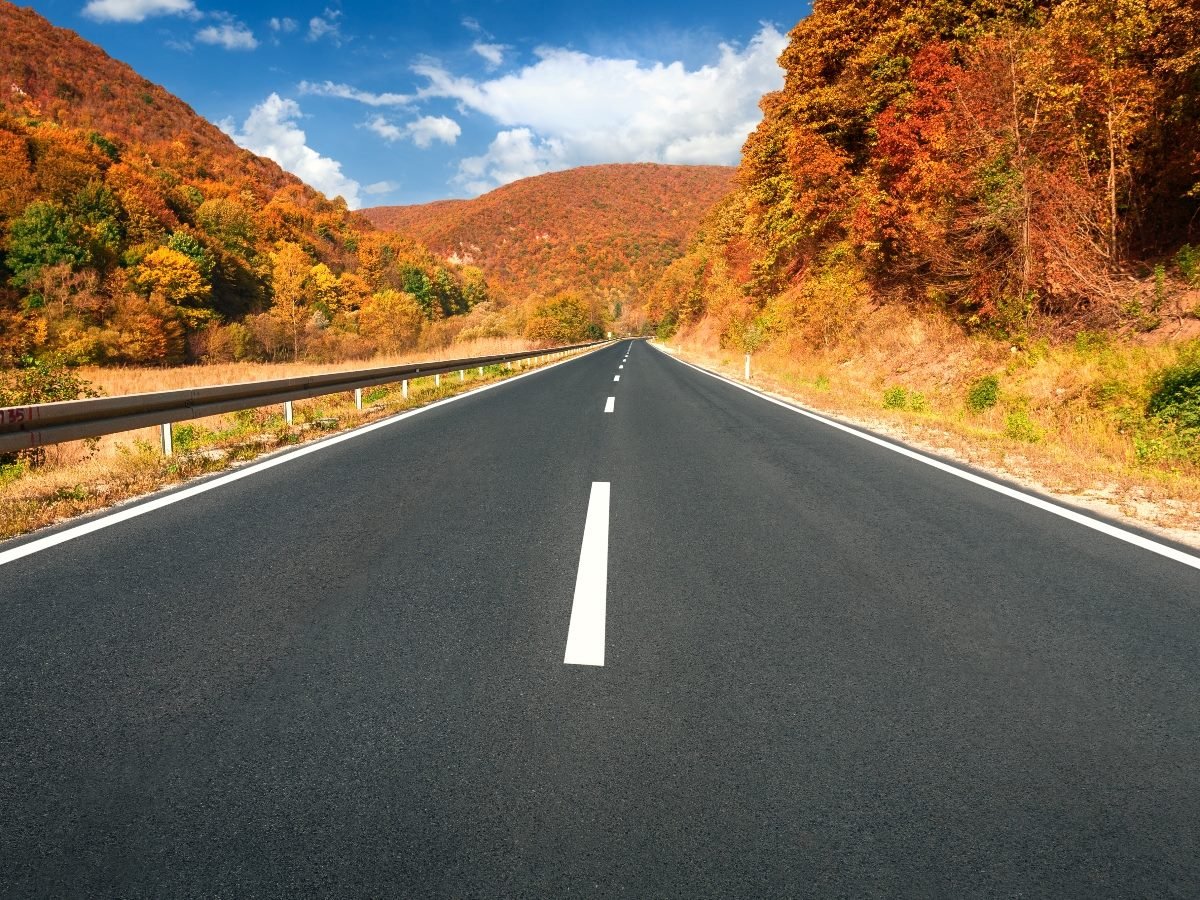 Driving on asphalt road through the hills at autumn.